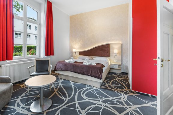 Göhren Rügen Waldhotel SPA Blick in ein Zimmer mit roten Vorhängen