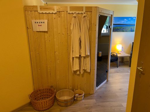 Wohlfühlbereich mit Holzverkleidung, Handtüchern, Körben und gemütlicher Beleuchtung.